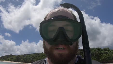 Caucasian,-bearded-man-take-a-selfie-of-himself-putting-on-a-snorkelling-mask-and-diving-underwater