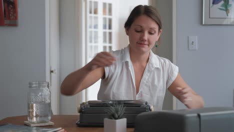 Wide-shot-caucasian-woman-loading-paper-into-typewriter