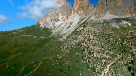 Camera-drone-flying-sideways-along-the-rock-faces-of-imposing-mountain-peaks-in-the-Italian-Dolomites