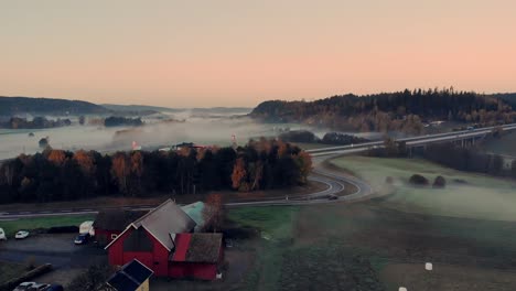 Aerial-over-road-cutting-through-the-farmland-near-Bollebyggd,-Sweden