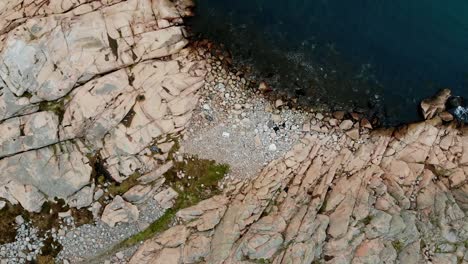 Overhead-aerial-zoom-out-over-the-rocky-shoreline-near-Lysekil,-Sweden
