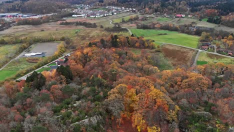 Low-aerial-footage-panning-across-housing,-forests-and-fields-near-Kallered,-Molndal,-Gothenberg,-Sweden
