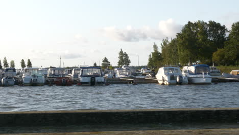 Small-boats-docked-at-marina-in-Finland,-slow-panning-shot