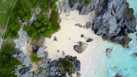 Aerial-drone-shot-over-a-small-beach-by-a-park-in-Bermuda