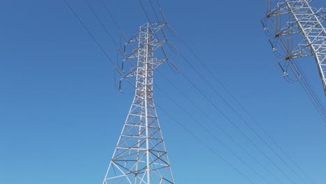 Electricity-transformer-tower-on-a-blue-sky-backdrop-with-electric-cable-wires-lines