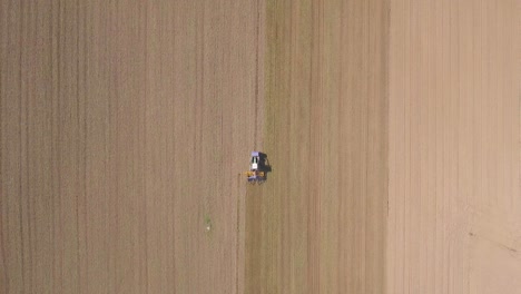 Overhead-drone-shot-of-Tractor-working-and-cultivating-farm-land