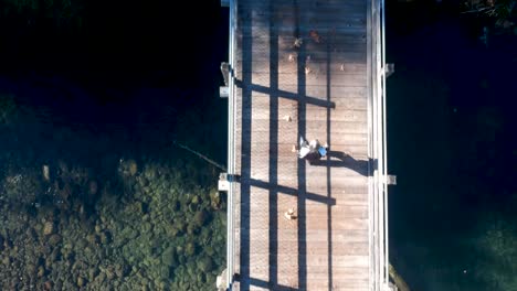 moving-drone-shot-looking-down-at-woman-walking-on-trestle-in-British-Columbia-Canada