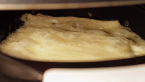 extreme-close-up-of-raclette-slice-cheese-melting-and-bubbling