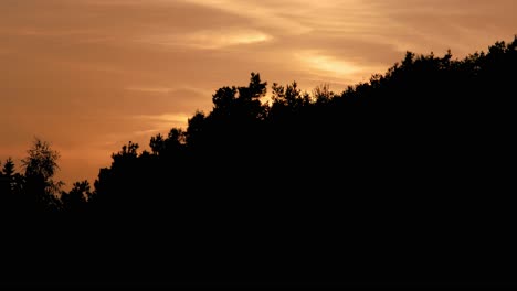 Erstaunlicher-Zeitraffer-Des-Abend--Oder-Morgenhimmels-Mit-Orangefarbenen-Und-Gelben-Wolken-über-Dem-Wald