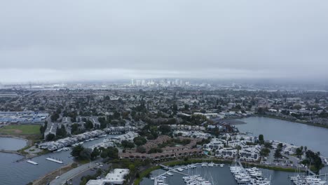 A-large-city-in-the-background-of-the-marina-and-sailboats