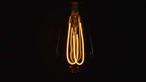 Lightbulb-flickering-on-black-background.-Filmed-in-4k
