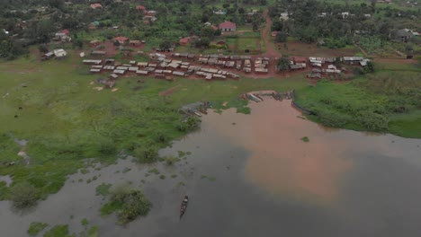 Aerial-shot-moving-forward-over-the-shores-of-Lake-Victoria-to-a-small-fishing-village-on-the-land