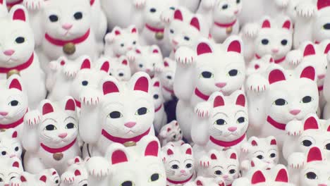 numbers-of-maneki-neko-cats-at-gotokuji-tokyo-japan,-tracking-left-shot