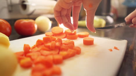 Female-hands-cutting-a-carrots-slices-in-the-kitchen-in-slow-motion