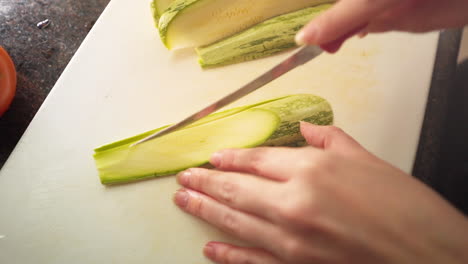 Zeitlupe-Weibliche-Hände-Schneiden-Eine-Grüne-Zucchini-In-Der-Küche-In-Zeitlupe