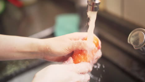Zeitlupenaufnahme-Weiblicher-Hände,-Die-Einige-Karotten-Unter-Wasser-Aus-Einem-Küchenhahn-Waschen