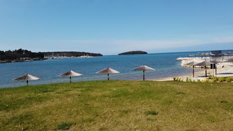 Driving-Past-Polidor-Camp-Ground-Past-Beach-And-Parasols,-Croatia