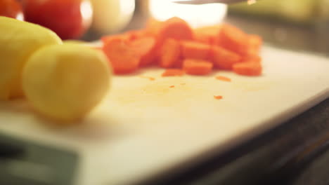 Female-hands-cutting-carrots-in-the-kitchen