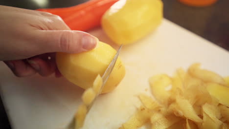 Close-up-female-hands-peeling-potatoes-in-the-kitchen-in-slow-motion