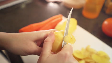 Female-hands-peeling-potatoes-in-the-kitchen-in-slow-motion