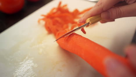 Manos-Femeninas-Pelando-Zanahorias-En-La-Cocina-A-Cámara-Lenta