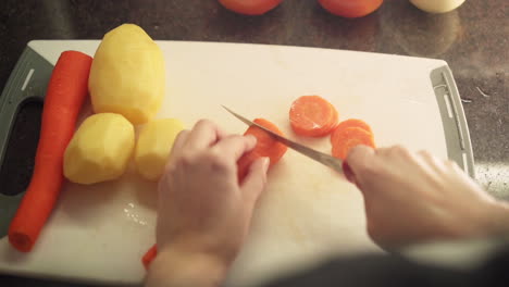 Frauenhände-Schneiden-Karotten-In-Der-Küche-In-Zeitlupe