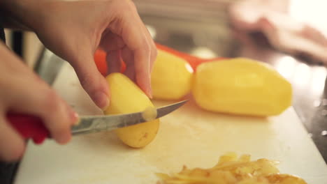 Manos-Femeninas-Pelando-Patatas-En-La-Cocina-A-Cámara-Lenta