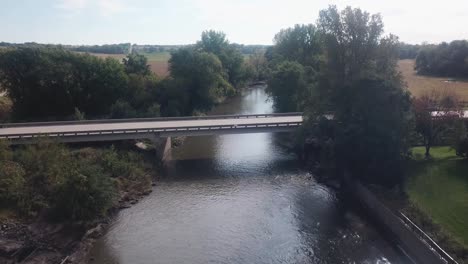 Point-of-view-slow-drone-flight-of-low-altitude-flight-over-a-bridge-crossing-Skunk-River-river-running-through-rural-Iowa-USA