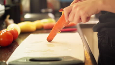 Female-hands-peeling-carrots-in-the-kitchen-in-slow-motion