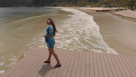 A-woman-walks-out-on-a-jetty-on-the-most-famous-beach-Maracas-located-on-the-north-coast-of-Trinidad