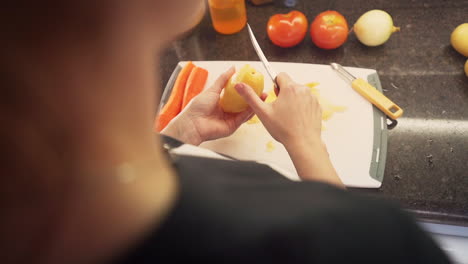 Woman-peeling-potatoes-in-the-kitchen-in-slow-motion