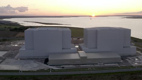 Atomkraftwerk-Mit-Wunderschönem-Goldenen-Sonnenuntergang-An-Einem-Fluss,-Hoher-Drohnenwinkel