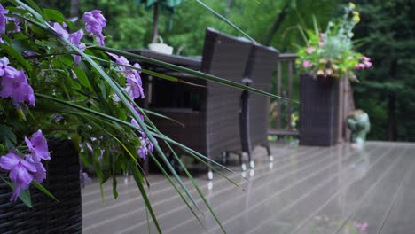 A-verdant-woodland-lays-behind-a-gorgeous-deck,-featuring-wicker-furniture-and-lush-planters