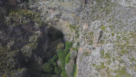 Aerial-tilt-down-shot-over-rocky-mountains-with-a-river-deep-in-the-cliff-in-the-iberian-system