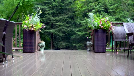 Ein-Grüner-Wald-Liegt-Hinter-Einer-Wunderschönen-Terrasse-Mit-Korbmöbeln-Und-üppigen-Pflanzgefäßen