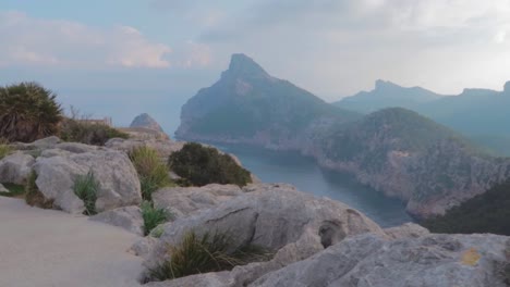 Ein-Panoramablick-Auf-Die-Balerische-Insel-Von-Der-Spitze-Des-Hügels,-Mit-Schönem,-Angenehmem-Nebelwetter,-Umgeben-Von-Kalksteinbergen-Und-Wilden-Pflanzen,-Zeitlupe