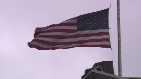 AMERICAN-FLAG-AND-POW-MIA-FLAG-AT-HALF-STAFF-ON-WINDY-DAY-SLOW-MO