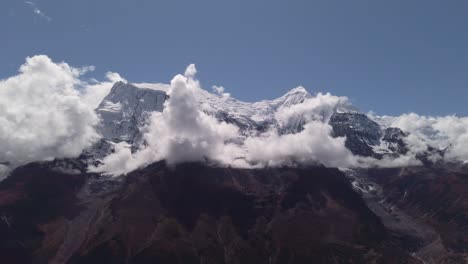 clouds-running-on-blue-sky-over-amazing-white-landscape-of-high-rocky-mountains-and-snowy-valley-himalaya-nepal-annapurna-circuit