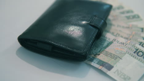 Pan-from-right-to-left:-100-polish-zloty-under-black-wallet