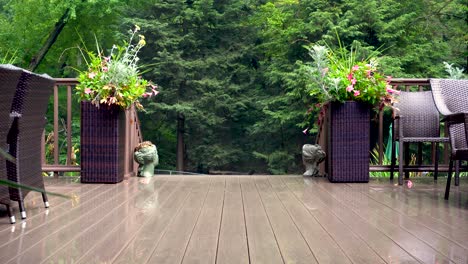 A-verdant-woodland-lays-behind-a-gorgeous-deck,-featuring-wicker-furniture-and-lush-planters