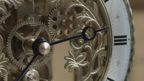 Closeup-shot-of-ornate-brass-clock-with-hands-stationary-near-three-o'clock