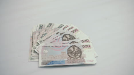 Focus-on:-a-lot-of-500-polish-zloty,-lie-on-the-center-of-white-table