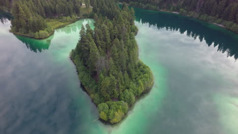 Reflective-Clouds-off-Emerald-Lake-Around-Peninsula-Revealing-a-Trail