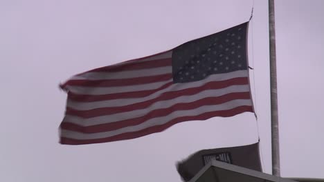 AMERICAN-FLAG-AND-POW-MIA-FLAG-AT-HALF-STAFF-ON-WINDY-DAY