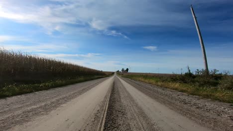 Doble-Tiempo,-Imágenes-De-Punto-De-Vista-Mientras-Conduce-Por-Un-Camino-De-Grava-En-La-Zona-Rural-De-Iowa