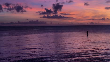 Grafischer-Lila-Sonnenuntergang-Mit-Silhouette-Des-Einsamen-Fischers-An-Der-Riviera