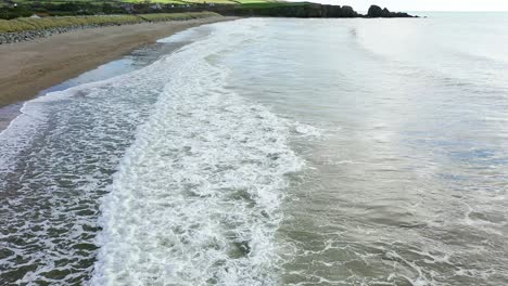 Luftaufnahme-Von-Wellen,-Die-An-Einem-Ruhigen-Strand-Im-Süden-Irlands-Hereinrollen