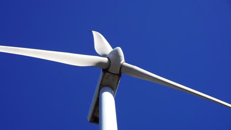 Nahaufnahme-Der-Rotorblätter-Einer-Windkraftanlage,-Die-Sich-Vor-Blauem-Himmel-Drehen
