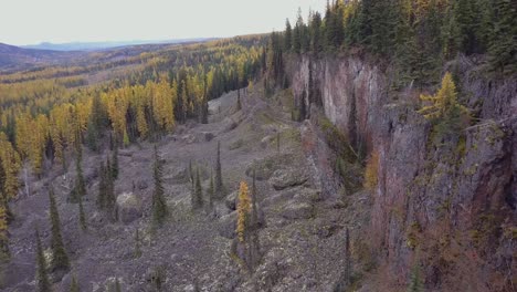 Aerial-shot-along-a-rugged-volcanic-cliff-face-with-pinnacles-and-fall-colours