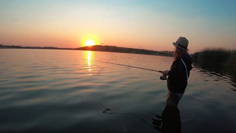 Ansicht-Des-Schönen-Mädchenfischens-Mit-Einem-Schönen-Sonnenuntergang-Im-Hintergrund-In-Südafrika